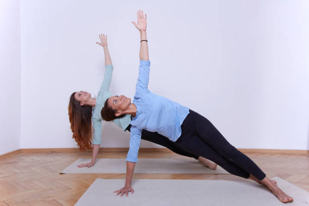 istock Two yoga master performing yoga workout. Pose Wild Thing 1096652640