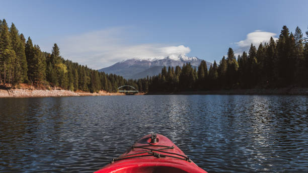 Kayaking on Lake Siskiyou, California with Mount Shasta in the background Mount Shasta and Wagon Creek Bridge with a red kayak in the foreground siskiyou lake stock pictures, royalty-free photos & images