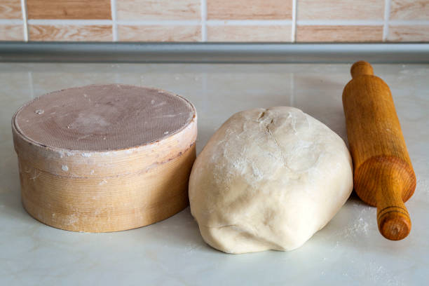 Dough bread, pizza or pie recipe homemade rolling pin preparation on kitchen table. Working with pastry or bakery cooking.