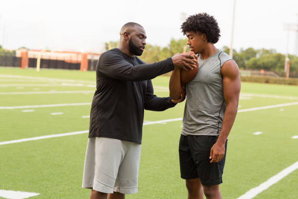 istock American Football coach training a young athlete. 1096706756