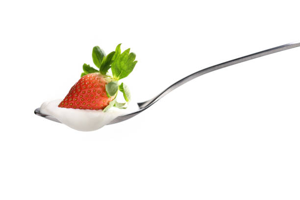 istock Plain yogurt on a spoon with fresh strawberry on top isolated on white background 1096734066