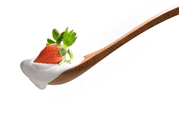 istock Plain yogurt on a spoon with fresh strawberry on top isolated on white background 1096734080