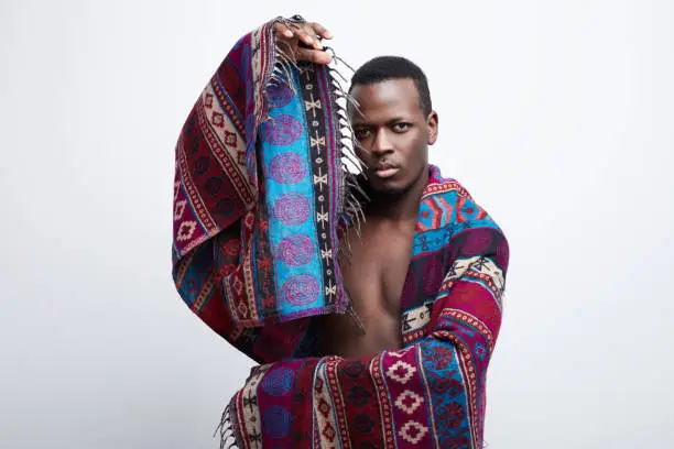 Photo of Handsome dark skinned male gesturing over studio background