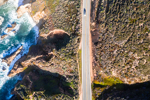 Coastline Road Highway 1 California Ocean BigSur Car is driving Birdview from Drone