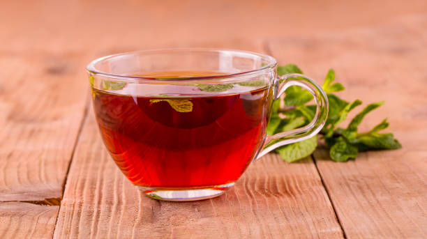 istock The tea cup with mint on old wooden background. 1096754744