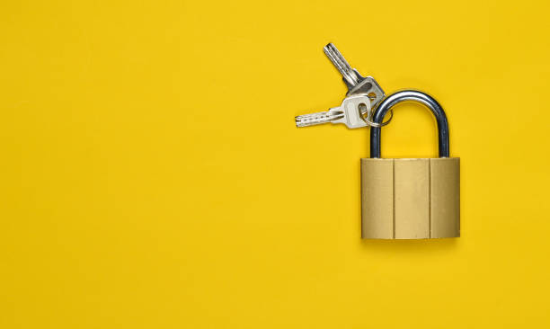 istock Golden closed lock with keys on a yellow background. Copy space. Top View 1096763354