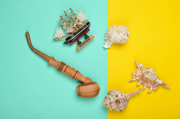 istock Decorative ship, seashells, chicken pipe on a colored pastel background. Captain shipwreck.  Summer Beach Concept. Top view, minimalism 1096763398
