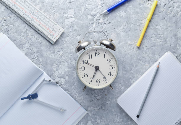istock Education equipment. Alarm clock, notepad, ruler, pen, compasses on a gray concrete background. Top view, flat lay style 1096764882