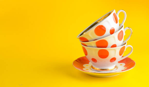 istock stack of antique ceramic cups on a saucer on a yellow background, copy space 1096765298