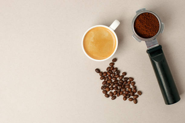 istock coffee in white cup, coffee beans and handle coffe machine filter on gray board from above, minimal conceptual photo, Morning coffee routine 1096765544