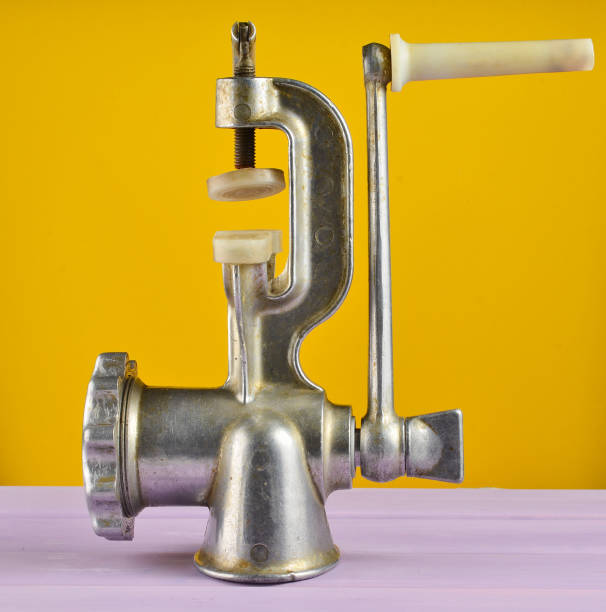 vintage meat grinder on a yellow pastel background. minimalism trend - old fashioned domestic kitchen old close up imagens e fotografias de stock