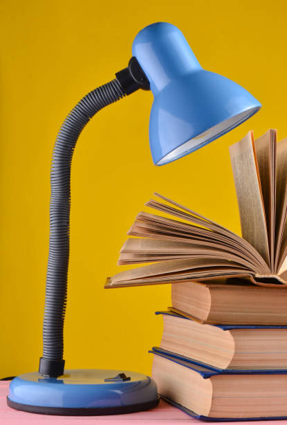 istock table lamp and a stack of books on a table isolated against a yellow wall background 1096768892