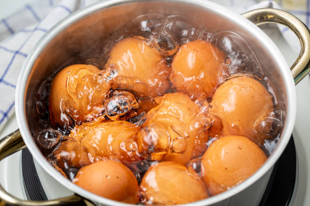 cooking chicken eggs on electric stove cooking brown chicken eggs in boiling water on electric stove, closeup, elevated view boiling photos stock pictures, royalty-free photos & images