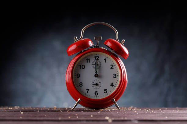 istock Red vintage retro alarm clock on a dark background. 1096793002