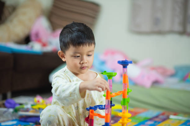 istock cute boy playing with toy at home 1096797474