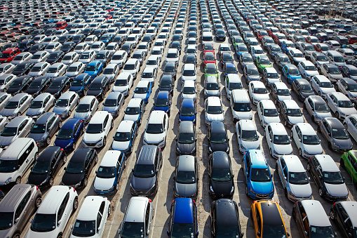 Barcelona, Spain - April 10, 2018:  Aerial view of new modern passenger cars stored on large parking lot in the Port de Barcelona waiting for their next distribution.