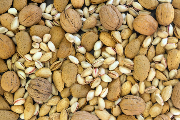 istock Different types of nuts- assorted walnuts, almonds and pistachios. Concept- healthy diet,  full source of vegetable protein in vegetarianism and raw food. Background. 1096807220