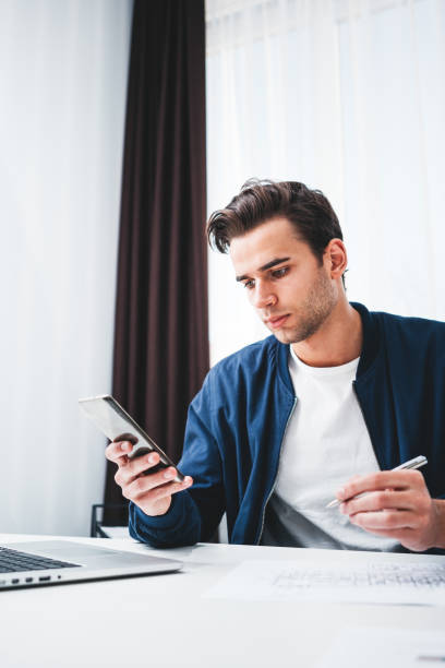 istock Young businessman sitting in office and working on smartphone and computer. Portrait of manager in office using mobile phone 1096807400