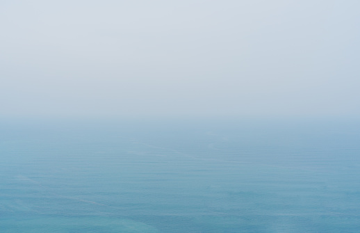 Blue sea with mist and overcast sky, mystery environment over ocean