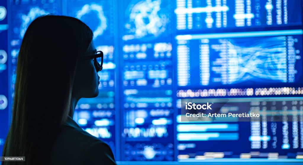 The businesswoman standing near the blue display Data Stock Photo