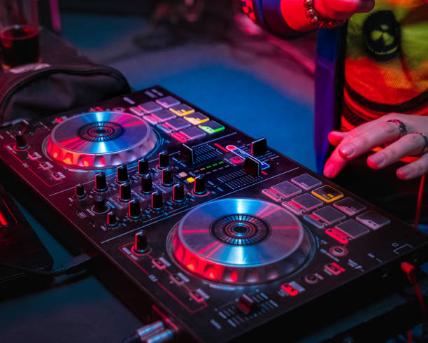 istock DJ  hands under DJ music console, laptops and headphones 1096813108