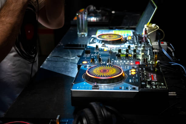 istock DJ  hands under DJ music console, laptops and headphones 1096815410