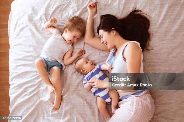 Happy Loving Family Of Mother And Two Sons Young Mom Relaxing And Hugging  With Her Children At Evening Stock Photo - Download Image Now - iStock