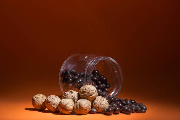 nuts and chocolate pralines spilled from a glass jar