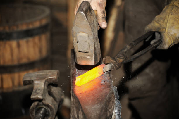 istock Blacksmith working metal with hammer on the anvil 1096832386