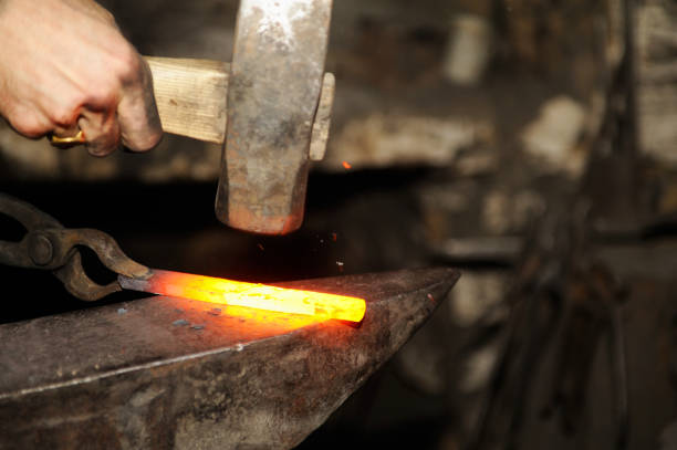 istock Blacksmith working metal with hammer on the anvil 1096832408