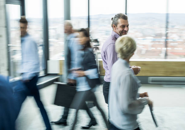 istock Smiling businessman talking to his colleague while walking in a hallway. Blurred motion. 1096839366