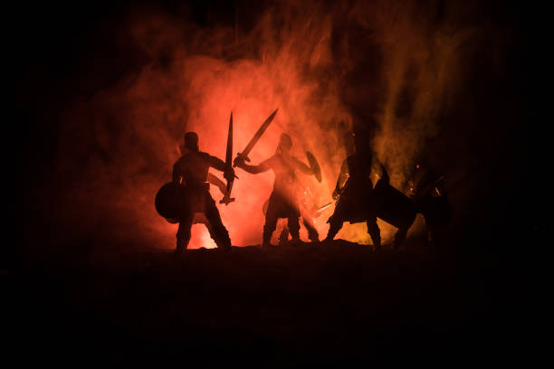istock Medieval battle scene. Silhouettes of figures as separate objects, fight between warriors on dark toned foggy background. Night scene. 1096840852