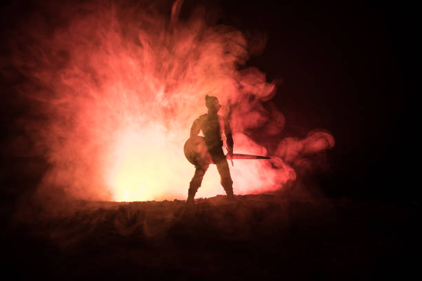 istock Medieval battle scene. Silhouettes of figures as separate objects, fight between warriors on dark toned foggy background. Night scene. 1096840860
