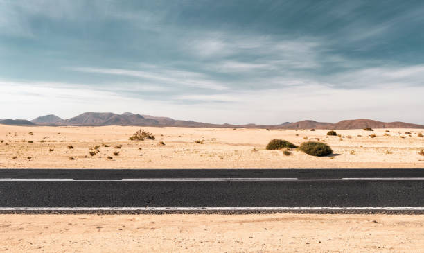 Empty desert road with copy space Empty road through the desert dunes with copy space atlantic islands photos stock pictures, royalty-free photos & images