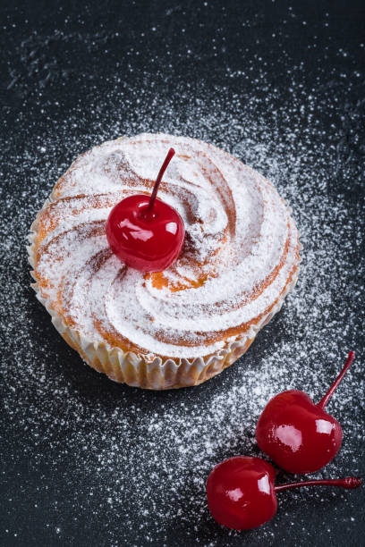 istock Muffin in powdered sugar with cherries over black texture background. 1096845216