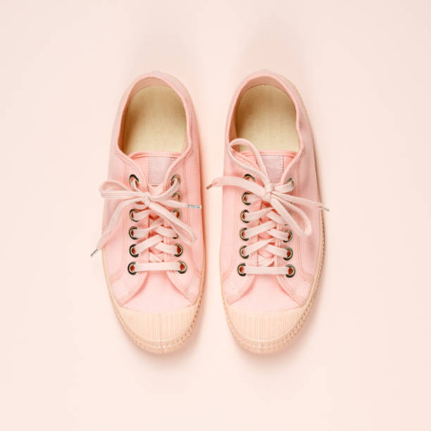 istock Pink canvas sneakers on pink background, close up 1096846842