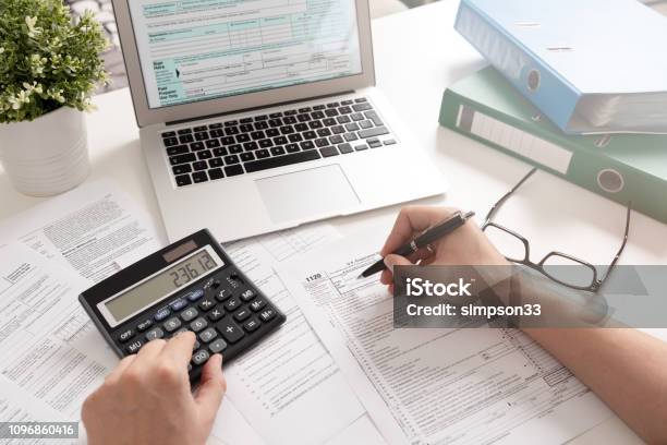 Accountant Working With Us Tax Forms Stock Photo - Download Image Now - Tax, Accountancy, Financial Advisor