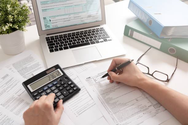 accountant working with us tax forms - tax tax form financial advisor calculator imagens e fotografias de stock