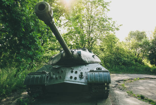 istock Old tank from the Second World war standing outdoors in the green forest. Caterpillar track in the grass. Armored fighting vehicle as a memory monument in peaceful times. No war concept. 1096861456