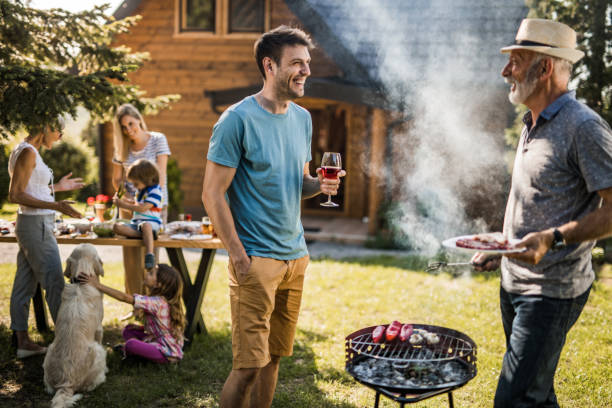 istock Happy men talking while preparing barbecue for his family in the backyard. 1096861888