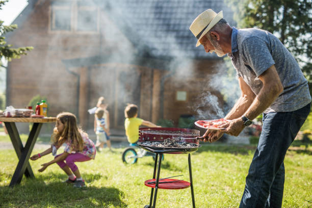 istock Mature man man preparing meat for barbecue grill in the backyard. 1096862082