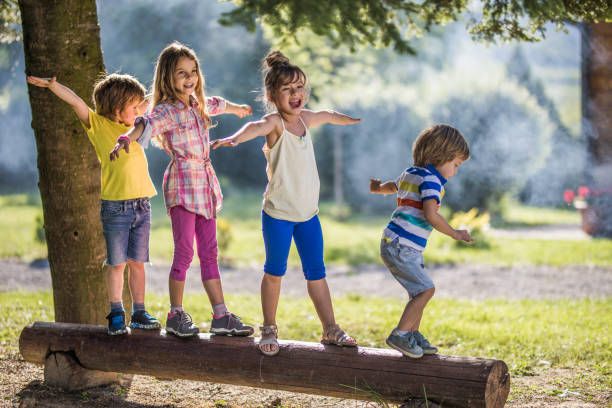 istock Group of small kids walking on a tree trunk in nature. 1096863762