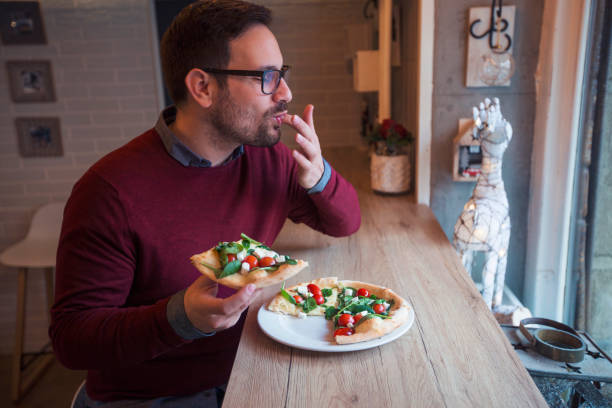 man enjoying tasty pizza - morning tomato lettuce vegetable imagens e fotografias de stock