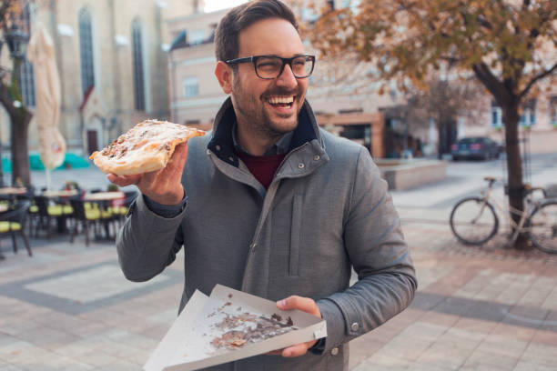 istock Happy man holding slice of pizza 1096865246