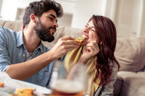 istock Loving couple relaxing at home and eating pizza 1096866522