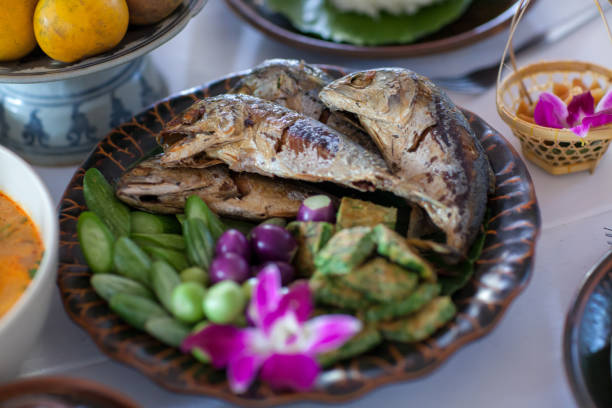 fried mackerel fish in blue dish. Shrimp paste sauce and vegetable set. Thai food. Fried mackerel with shrimp paste sauce and vegetable set. Rastrelliger brachysoma Two fried mackerel with green salad