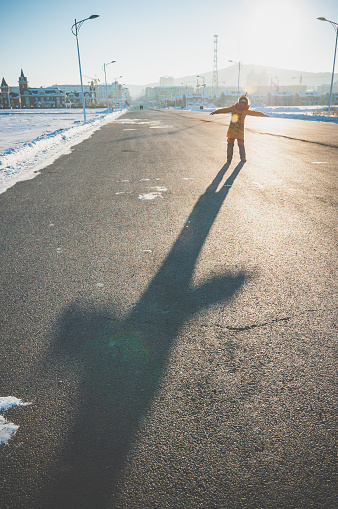 A Chinese woman walking on the snow ground in the winter.