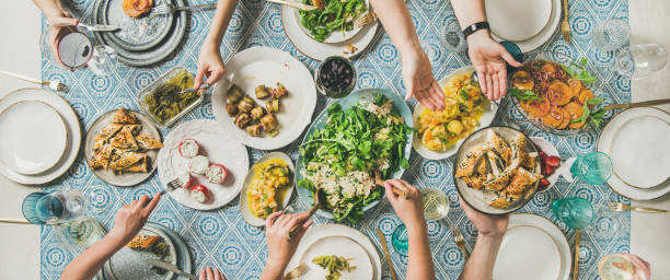 istock Flat-lay of hands holding mediterranean starters and drinks, wide composition 1096874870