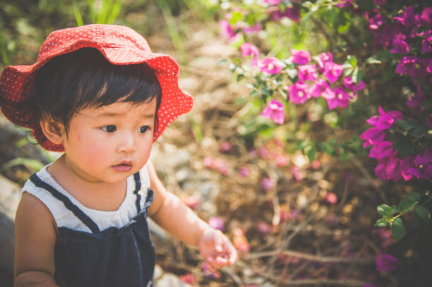 A Asian baby girl playing on the lawn.