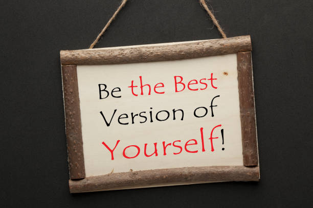 Best Version Of Yourself text on wooden sign hanging on a rope on black background. Motivational concept